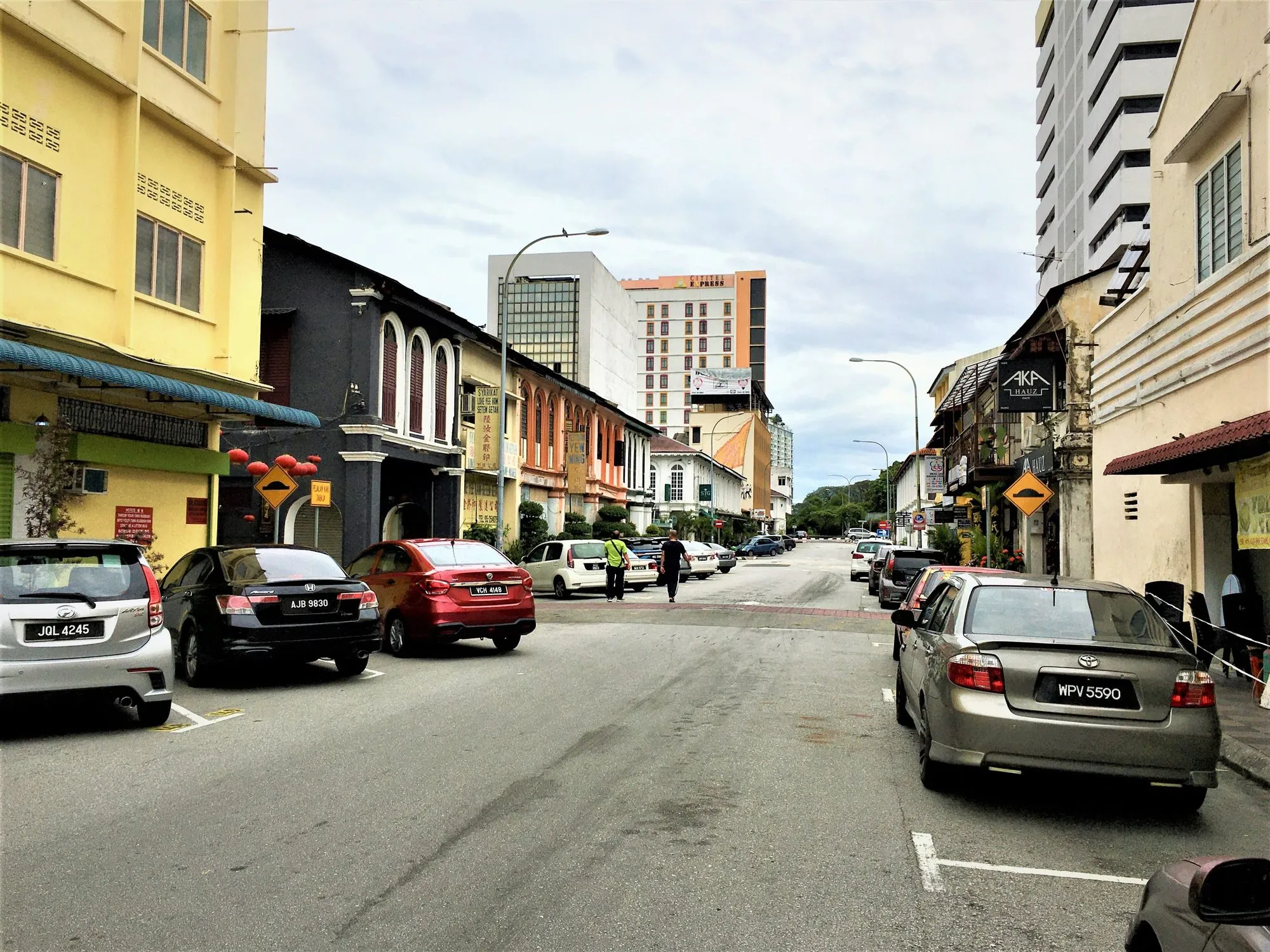 Jalan Bandar Timah in Ipoh Old Town, lined with heritage shophouses, parked cars and red lanterns