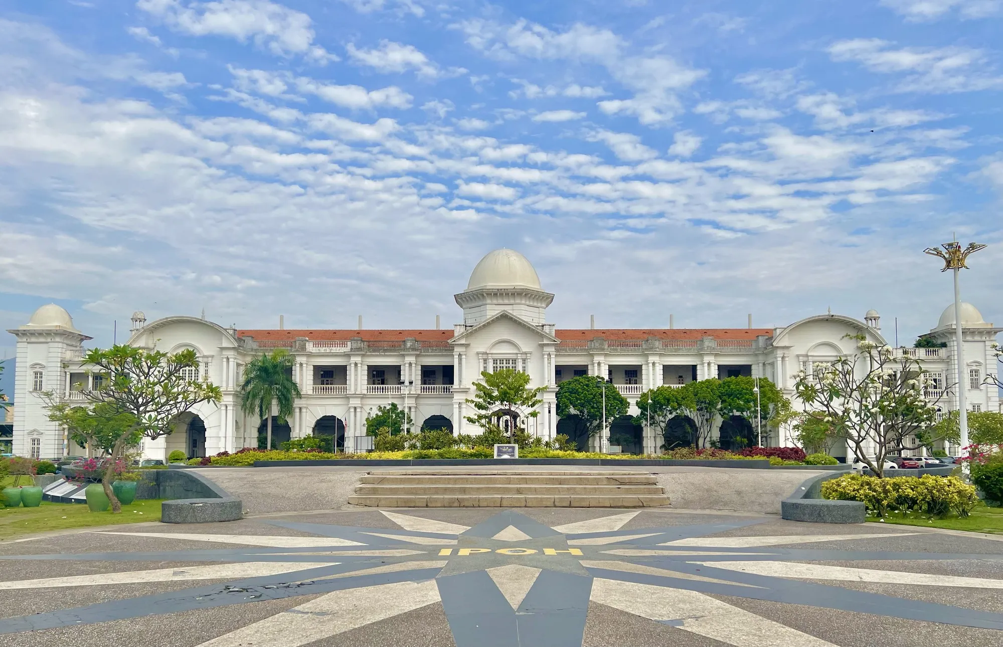 Wide paved square with a star-patterned pavement in front of Ipoh Railway Station