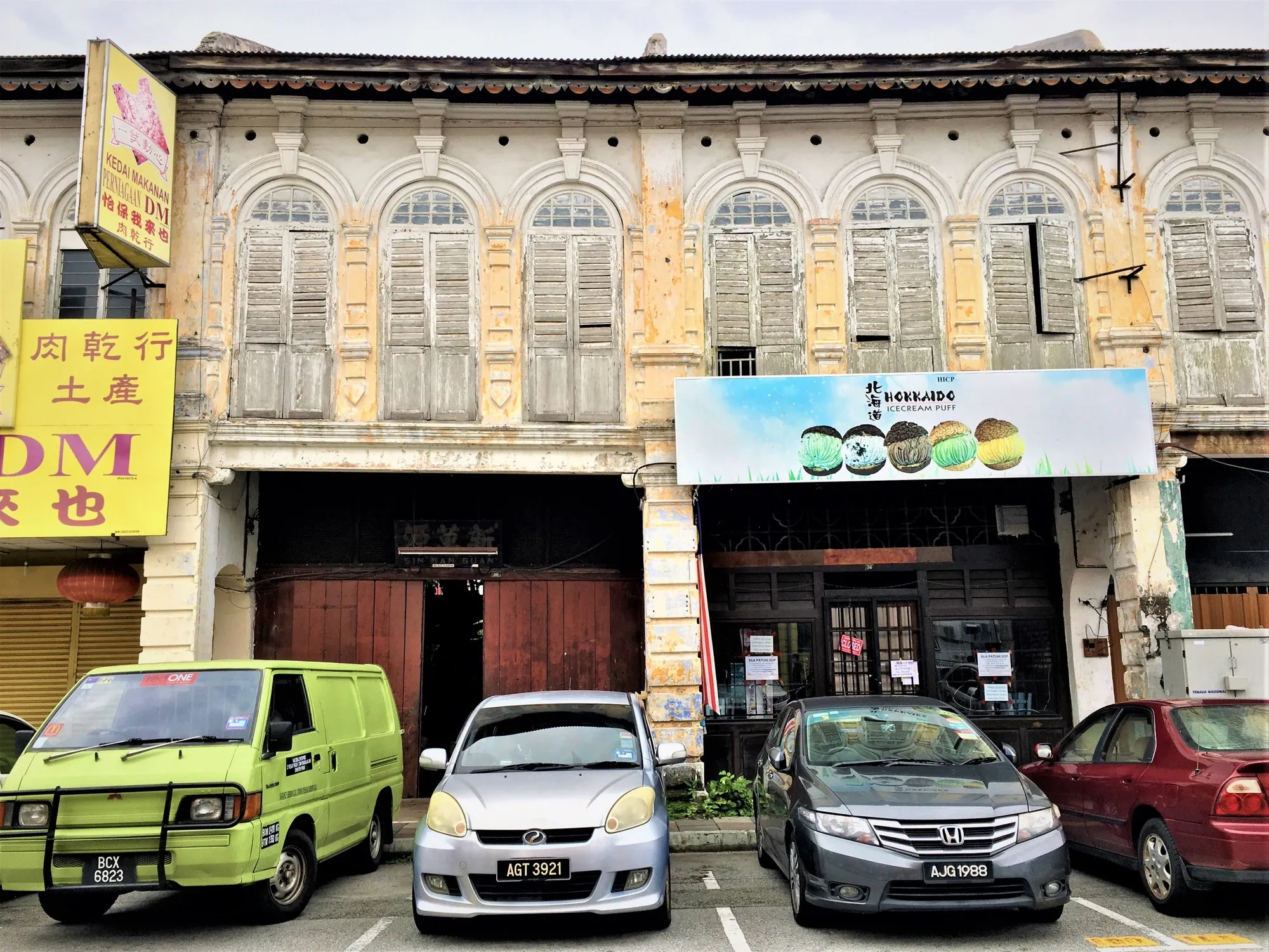 Row of old two-storey shophouses with tall shuttered windows along Jalan Yau Tet Shin, Ipoh