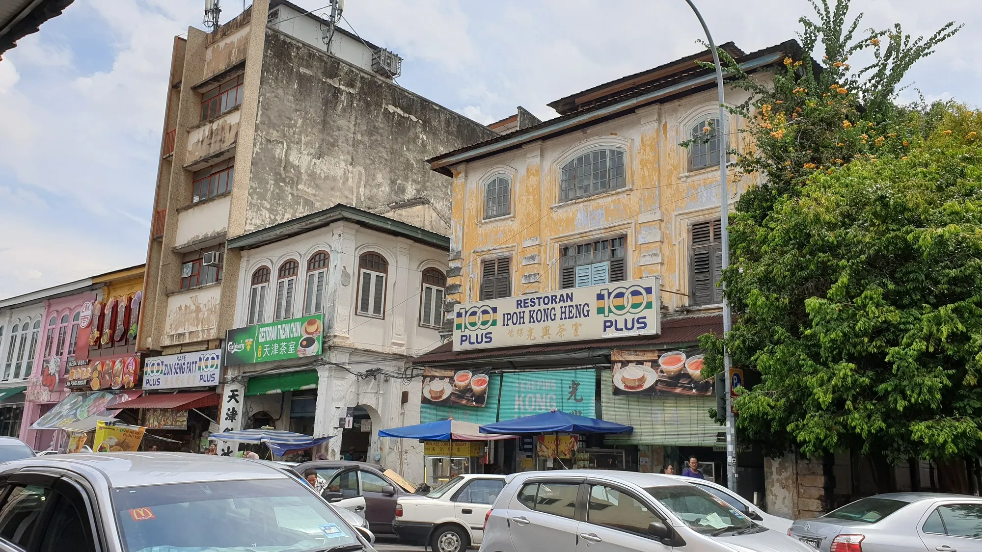 Heritage shophouses around the Kong Heng block in Ipoh Old Town, with parked cars in front