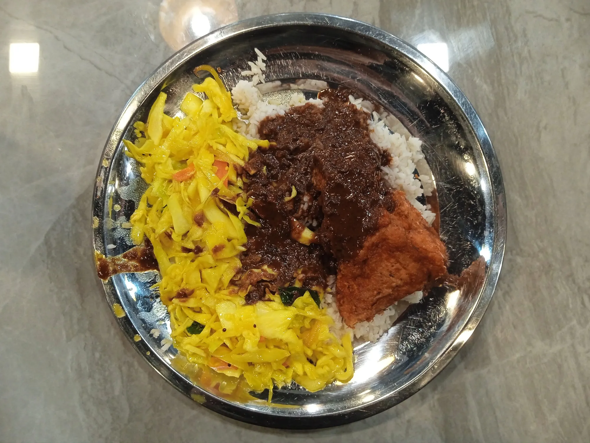 Steel plate of rice with mixed curries, fried chicken and yellow cabbage