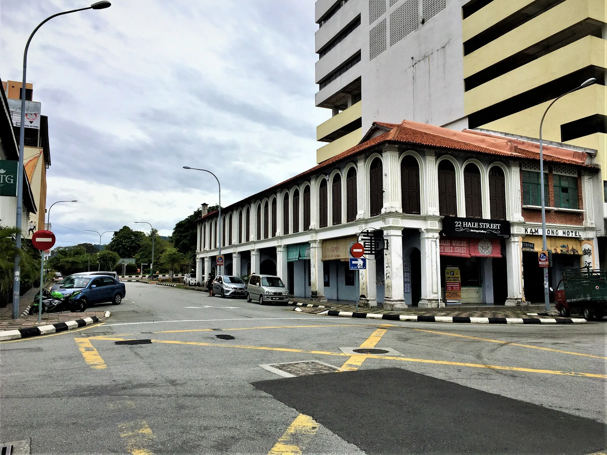 Two-storey heritage corner shophouse block with arcaded walkways at a quiet Old Town junction in Ipoh