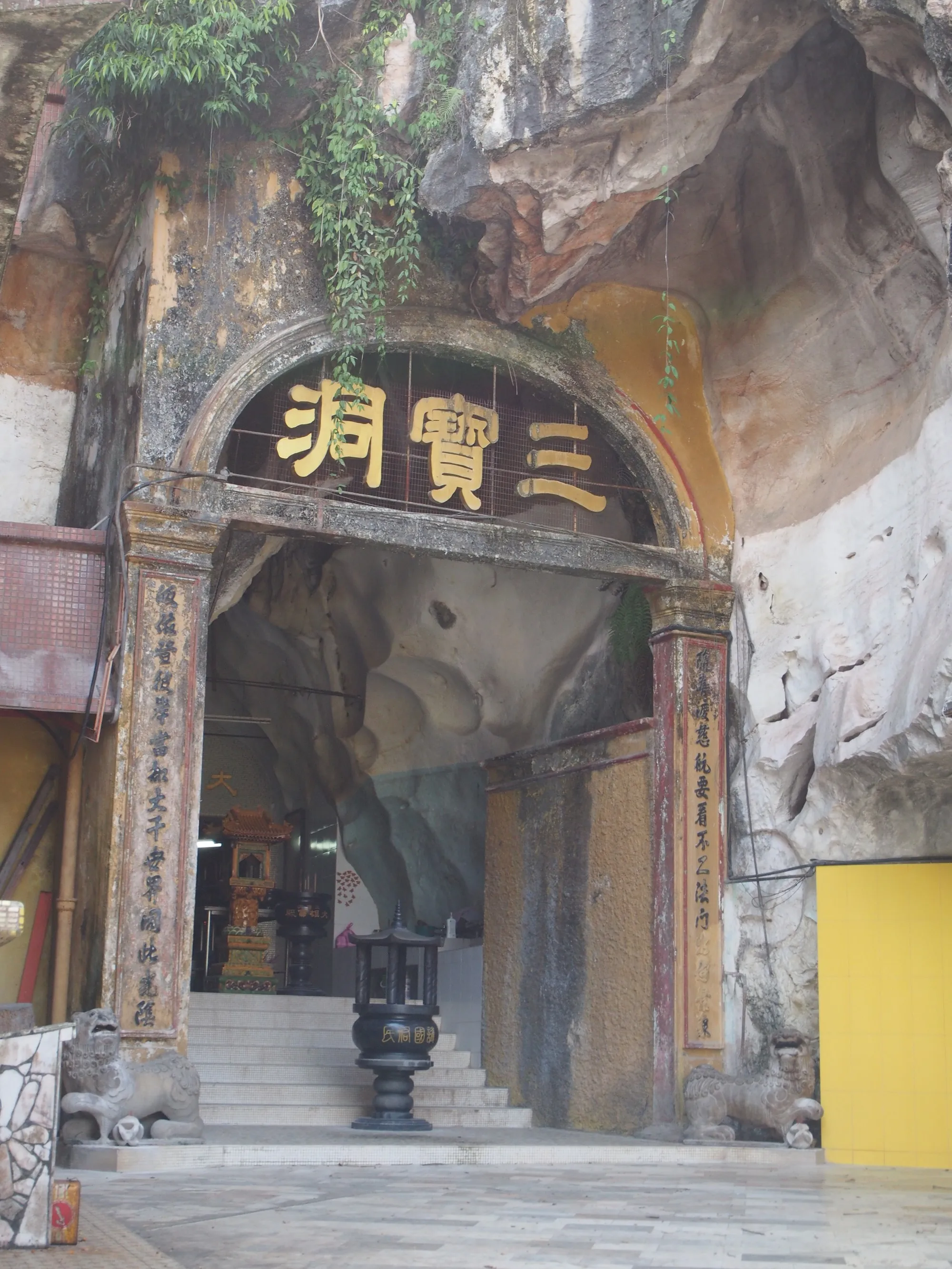 Cave entrance with a Chinese name plaque set into the rock at Sam Poh Tong temple