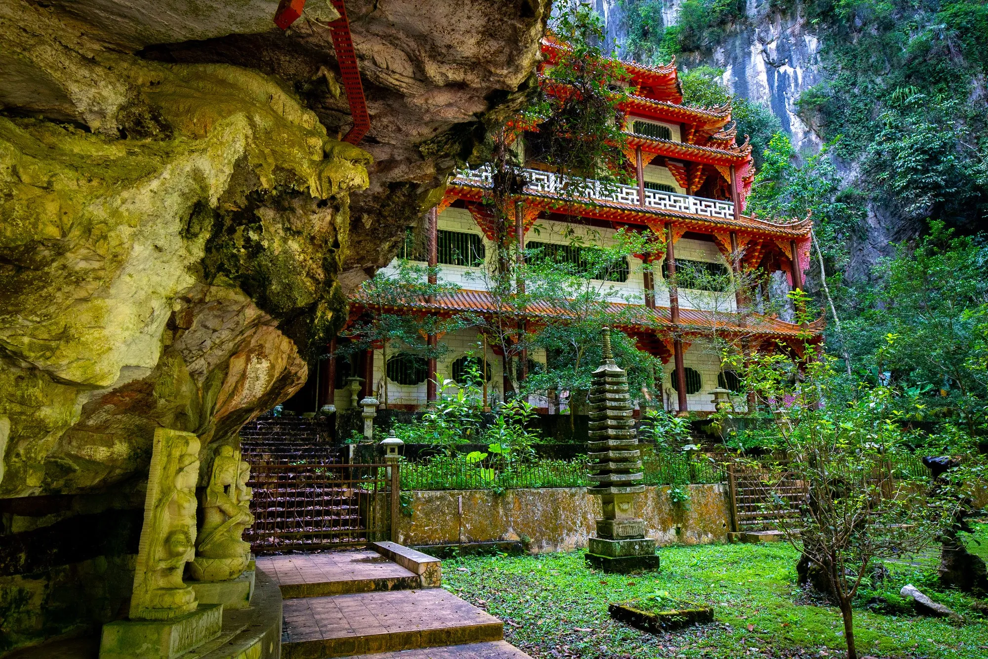 Multi-storey Chinese temple facade built into a towering limestone cliff at Sam Poh Tong, Ipoh